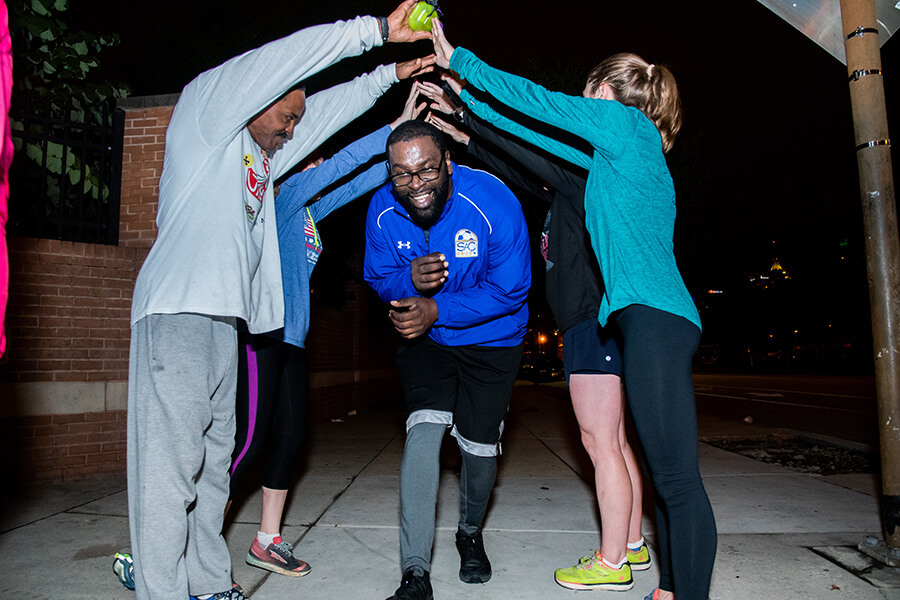 Reggie Douglas passes through a Back On Our Feet running group victory tunnel following the completion of a three-mile run through Baltimore Oct. 15. (Kevin J. Parks/CR Staff)