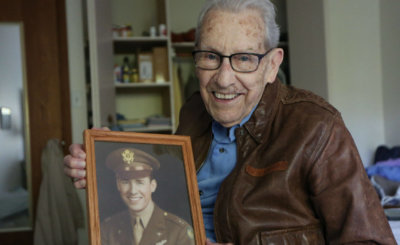 Don Stoulil of Sacred Heart Parish in Robbinsdale, Minn., holds a picture of himself Oct. 30, 2019, which was taken near the end of his tour of duty in World War II as a B-17 bomber pilot.