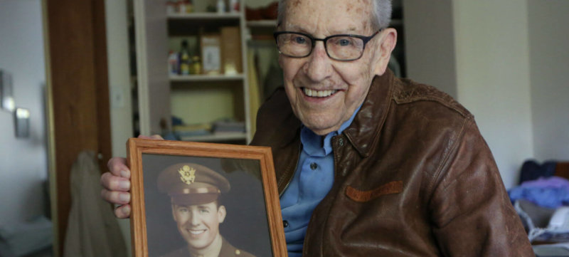 Don Stoulil of Sacred Heart Parish in Robbinsdale, Minn., holds a picture of himself Oct. 30, 2019, which was taken near the end of his tour of duty in World War II as a B-17 bomber pilot.