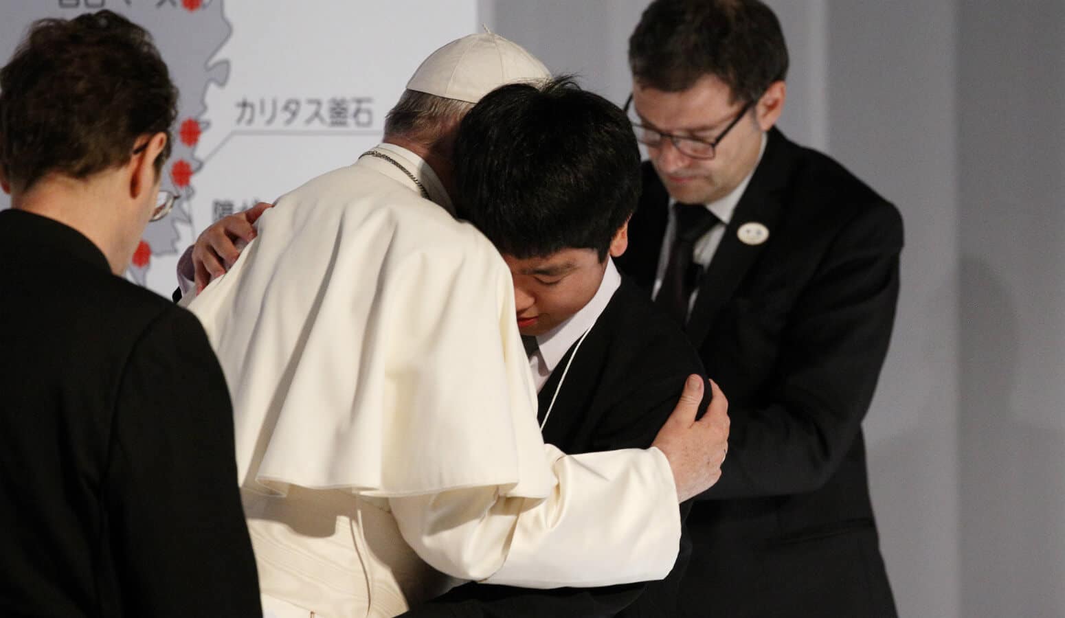 Pope Francis embraces a young man as he meets with victims of the 2011 "triple disaster" (earthquake, tsunami and nuclear power plant meltdown) at Bellesalle Hanzomon, Tokyo, Japan, Nov. 25, 2019.