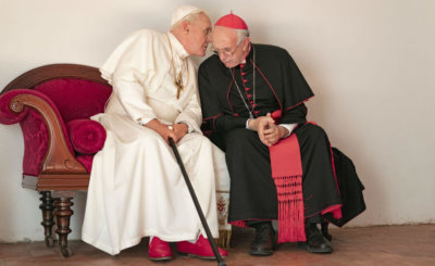 Anthony Hopkins portrays retired Pope Benedict XVI and Jonathan Pryce portrays Pope Francis in a scene from the movie "The Two Popes."